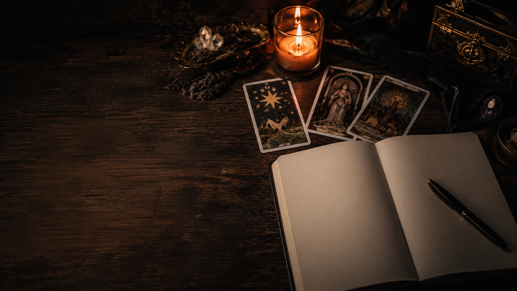 Karty tarota, świeca i otwarty notes na ciemnym stole — tarot dla początkujących